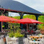 Hof-Restaurant mit roten Schirmen und vielen gemütlichen Sitzgelegenheiten.